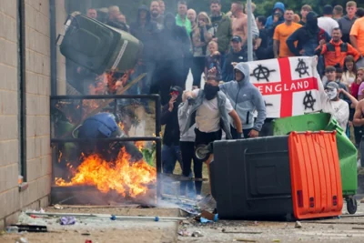 Protestors throw a garbage bin on fire