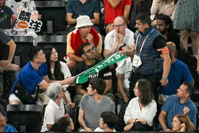 A security member removes a banner showing the name "Taiwan" from a fan.