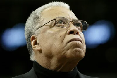 A head and shoulders photo of James Earl Jones. He has white hair and is wearing glasses