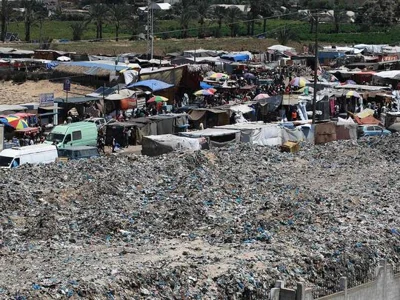 A pile of garbage surrounds a camp for displaced people in Khan Yunis