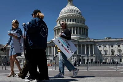 Four people stand in front of the U.S. Capitol on a sunny day. One woman holds a sign that says, “TikTok changed my life for the better.” 