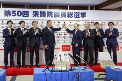 Japan's Prime Minister and president of the Liberal Democratic Party (LDP) Shigeru Ishiba, fourth from left, and the party's other senior members pose for a photo in front of the LDP candidates’ names of the lower house election seen on the board, at the party's headquarters Sunday, Oct. 27, 2024 in Tokyo, (Takashi Aoyama/Pool Photo via AP)