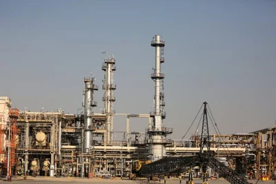 A refinery viewed against a dusty blue sky.