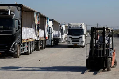 A row of trucks and a forklift.