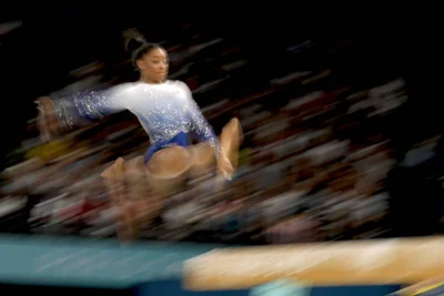 In this photo made with a slow exposure, Simone Biles, of the United States, warms up during the women's artistic gymnastics individual balance beam finals at Bercy Arena at the 2024 Summer Olympics, Monday, Aug. 5, 2024, in Paris, France. AP PHOTO