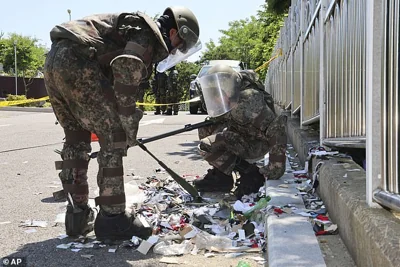 South Korean soldiers wearing protective gears check the trash from a balloon presumably sent by North Korea, in Incheon, South Korea, on June 2, 2024