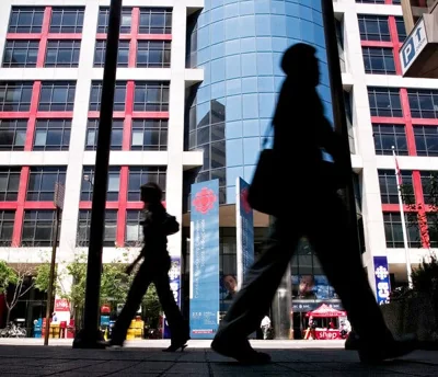 A view of people walking by an office building.