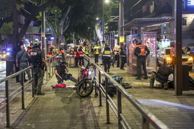 Israeli police and emergency workers stand by a body after a shooting attack in Jaffa, a mixed Arab-Jewish area of Tel Aviv, Israel