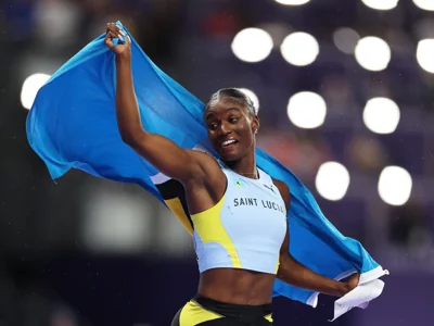 Julien Alfred celebrates with the Saint Lucian flag