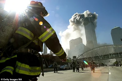 Firefighters walk towards one of the tower at the World Trade Center before it collapsed