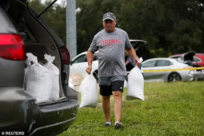 Rene Guerra carries sandbags, as they are distributed to Pinellas County residents before the expected arrival of Tropical Storm Milton, in Seminole, Florida on Sunday