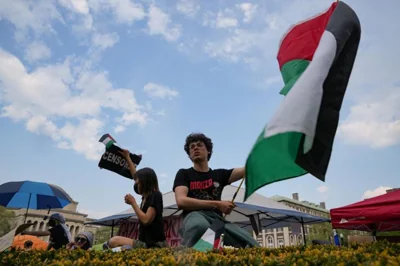A protester holds a Palestinian flag as students rally on Columbia University campus at a protest encampment in support of Palestinians in New York City, U.S., April 29. Reuters-Yonhap 