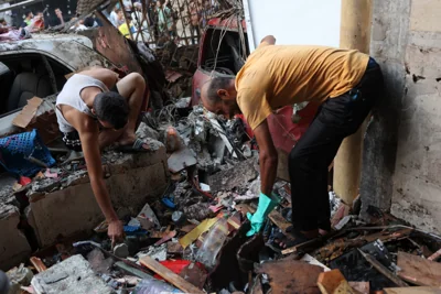 Rescue workers search the debris for people