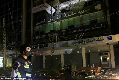 A member of Lebanon's emergency services walk at the site of an Israeli airstrike that targeted a building reportedly housing a Hezbollah backed financial institution, in the southern Lebanese city of Sidon