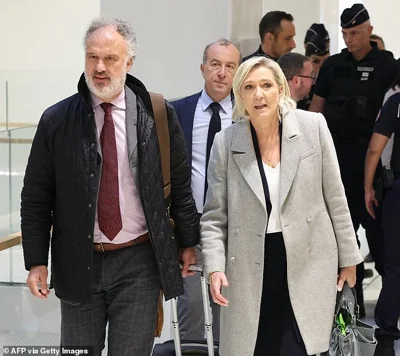 French far-right Rassemblement National (RN) Member of Parliament Marine Le Pen (C) arrives at a court house for a trial on suspicion of embezzlement of European public funds, in Paris on September 30, 2024