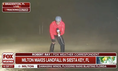 Robert Ray, a correspondent for Fox Weather could be seen on camera, complete with bike helmet and eye goggles, barely able to stand upright