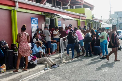 People queue outside a bus station in Scarborough, Trinidad and Tobago, before the arrival of hurricane Beryl