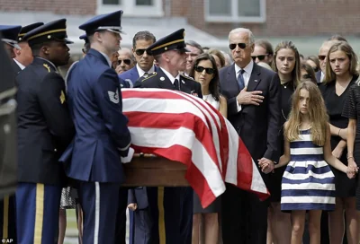 Biden, accompanied by his family, holds his hand over his heart as he watches an honor guard carry a casket containing the remains of his son, former Delaware Attorney General Beau Biden, into St. Anthony of Padua Roman Catholic Church in Wilmington on June 6, 2015. Standing alongside him are Beau's widow Hallie Biden, left, and daughter, Natalie. Beau Biden died of brain cancer May 30, 2015 at age 46