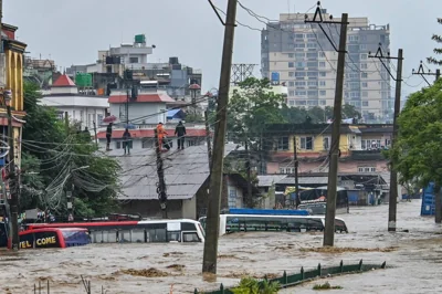 Residents climb over a rooftop as their neighbourhood submerged in flood waters after the Bagmati River overflowed following heavy monsoon rains in Kathmandu on September 28, 2024. AFP PHOTO