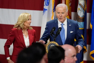 President Joe Biden speaks as first lady Jill Biden looks on at a Friendsgiving event with service members and their families in the Staten Island borough of New York, Monday, Nov. 25 2024