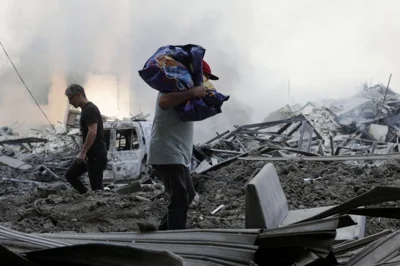 People walk over rubble following an Israeli airstrike in Beirut