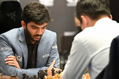 Gukesh Dommaraju and Ding Liren play chess.