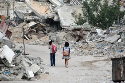 Girls walk past destroyed buildings in Khan Yunis in the southern Gaza Strip this week