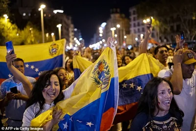 Venezuelan nationals residing in Spain hold their national flag during a demonstration to demand political change in their country during Venezuela's presidential election day, in Barcelona on July 28, 2024