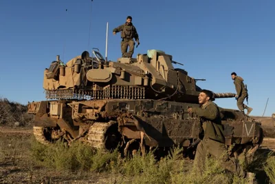 Israeli soldiers stand near a tank as it is moving along the Israeli-Lebanese border on Nov. 26, 2024. Israeli Prime Minister Benjamin Netanyahu said he supports a proposed 60-day ceasefire deal with Hezbollah, the Lebanese militant group whom Israel launched a ground invasion against nearly two months ago.