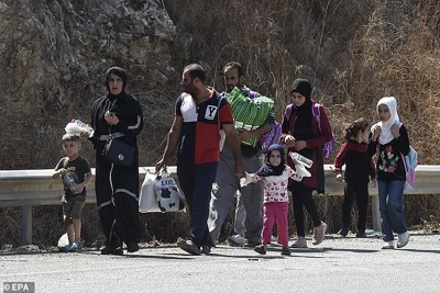 Lebanese people, fleeing southern Lebanon, walk with their belongings along the Damour highway towards Beirut amid a mass exodus of displaced people seeking shelter