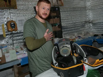 One of the medics demonstrates a piece of equipment used to treat injured soldiers