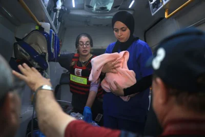 Medical workers care for a baby as ambulances carry patients from Kamal Adwan Hospital in northern Gaza's Beit Lahia to Shifa Hospital in Gaza City, on Oct. 12, 2024. Hospitals in northern Gaza are preparing to shut down services within hours due to the lack of fuel arriving from humanitarian corridors.