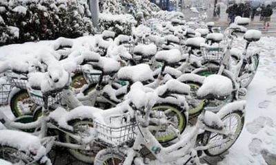 Snow-covered bicycles parked near a subway station in Seoul, South Korea