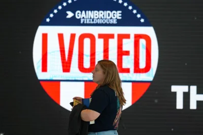 Woman in front of I voted sign