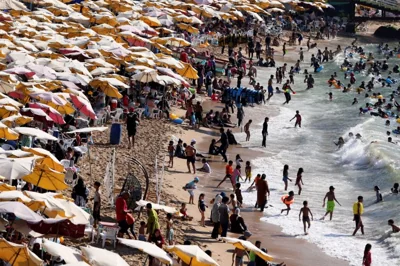 People crowd a public beach during a hot day amid a heatwave, in the Mediterranean city of Alexandria, Egypt