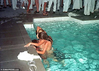 Two women pour champagne down a third woman's throat at Combs Labor Day party at his house in East Hampton in 1998