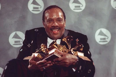 Quincy Jones cradles his Grammy awards