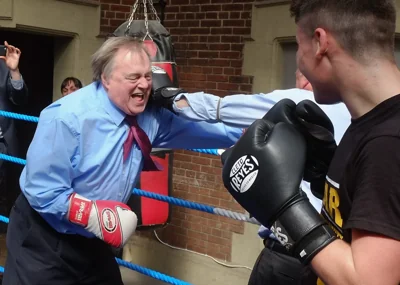 File: Former Deputy Leader of the Labour Party and Deputy Prime Minister, Lord John Prescott climbs into the ring to spar with journalist Michael Crick during a visit to an Amateur Boxing Club on 1 May 2015