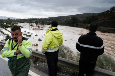 Three men inspect damage caused by flooding in Malaga, Spain, where heavy rain ripped through the region, sweeping away cars. Scientists say that increased episodes of extreme weather are likely tied to climate change