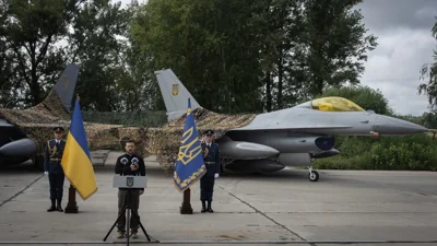 Президент Украины Владимир Зеленский выступает по случаю Дня Воздушных сил ВСУ, а за его спиной — два истребителя F-16