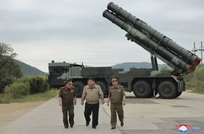 In this undated photo provided on Friday, Sept. 13, 2024, by the North Korean government, its leader Kim Jong Un, center, walks with other officials near what it says is their new launch vehicle of 600mm multiple rockets at an undisclosed location in North Korea. Independent journalists were not given access to cover the event depicted in this image distributed by the North Korean government. The content of this image is as provided and cannot be independently verified. Korean language watermark on image as provided by source reads: 