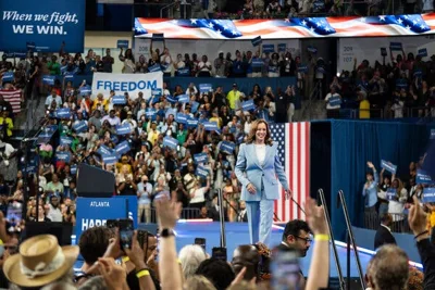 Kamala Harris smiles as she walks onstage at a campaign rally.