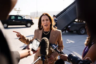 Kamala Harris talking to reporters on an airport tarmac in Las Vegas before boarding Air Force Two.