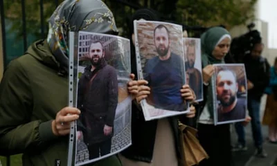 People hold portraits of Zelimkhan Khangoshvili, a Chechen dissident, murdered in Berlin in 2019.