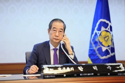 Prime Minister Han Duck-soo, who is acting president,  speaks with U.S. President Joe Biden over the phone at the Government Complex in Seoul, Sunday. Courtesy of Prime Minister's Secretariat