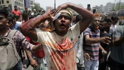 An injured protester is rushed to hospital after a clash with police and Awami League supporters at the Rampura area in Dhaka