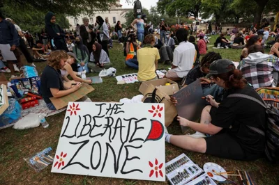 Protesters in Texas hold up a sign that reads "The Liberated Zone."