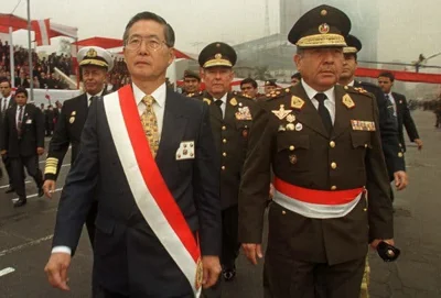 Alberto Fujimori and another official walking in military dress.