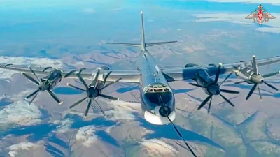 A Tu-95 strategic bomber of the Russian air force is refueled in the air during a join Russia-China air patrol