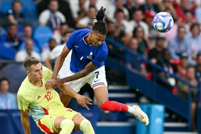 France's forward Michael Olise heads the ball next to Spain's defender Jon Pacheco in the men's gold medal final football match during the Paris 2024 Olympic Games at the Parc des Princes in Paris on August 9, 2024. AFP PHOTO